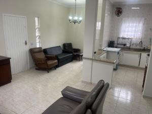 un grand salon avec un canapé et une cuisine dans l'établissement Casa Centro de Bertioga - SP terrea 300 metros da praia - Marcondes 05, à Bertioga