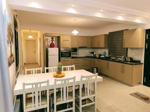 a kitchen with a white table and white chairs at Porto SkyLine in Porto Rafti