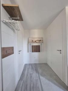 a room with white walls and wooden floors and a window at Top appart V9 in Village-Neuf