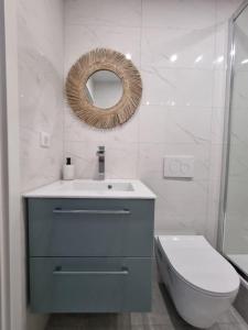 a bathroom with a sink and a toilet and a mirror at Top appart V9 in Village-Neuf