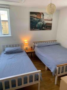 a bedroom with two beds and a picture of a car on the wall at Beach Walk in Radipole