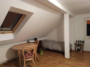 a room with a table and chairs and a bed at Chata łabedzia in Iłowa