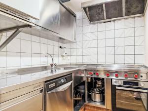 a kitchen with stainless steel appliances and white tiled walls at Holiday Home Gaugg by Interhome in Sankt Leonhard im Pitztal