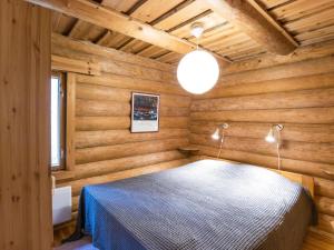 a bedroom with wooden walls and a bed in a room at Holiday Home Tunturitähti- lainio by Interhome in Ylläsjärvi