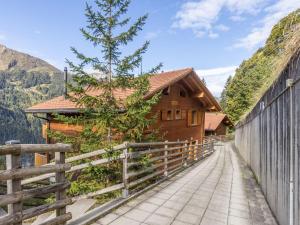 a wooden house with a fence next to it at Apartment Racer's Retreat Apt-12 by Interhome in Wengen