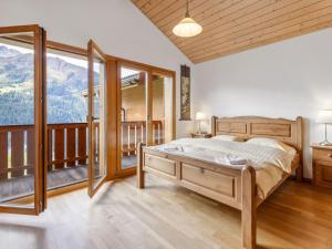 a bedroom with a bed and a balcony with mountains at Apartment Racer's Retreat Apt-07 by Interhome in Wengen