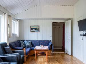 a living room with a blue couch and a table at Holiday Home Fjordglytt by Interhome in Onarheim