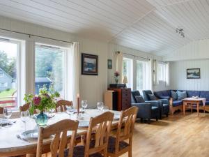 a dining room with a table and a couch at Holiday Home Fjordglytt by Interhome in Onarheim +22 photos