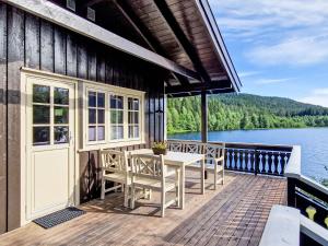 a house with a deck with a table and chairs at Holiday Home Staksholmen by Interhome in Konsmo
