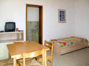 a room with a table and a bed and a dining room at Apartment Elbamar Lacona I-2 by Interhome in Capoliveri