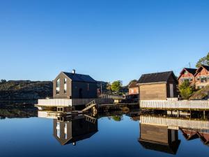 a house on a body of water with houses at Holiday Home Brosme by Interhome in Bømlo