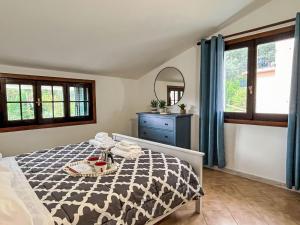 a bedroom with a bed and a dresser and windows at Apartment Asplanato - DOL166 by Interhome in Lecchiore
