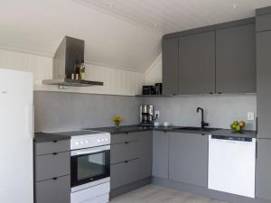 eine Küche mit weißen Geräten und grauen Schränken in der Unterkunft Holiday Home Torsk by Interhome in Bømlo + 33 Fotos