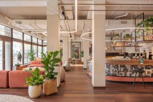 una hall d'ufficio con piante e un bar di Pods by The Usual Rotterdam a Rotterdam