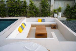 a white couch with yellow pillows and a table at Bahay Lian in Campo