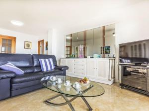 a living room with a blue couch and a glass table at Apartment Blanes Beach by Interhome in Blanes