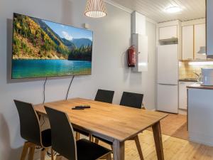 a kitchen and dining room with a wooden table and chairs at Holiday Home Vadelma by Interhome in Kukkola