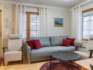 a living room with a gray couch and red pillows at Holiday Home Vadelma by Interhome in Kukkola