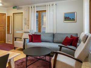 a living room with a blue couch and red pillows at Holiday Home Vadelma by Interhome in Kukkola +14 photos