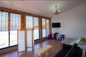 a living room with a couch and some windows at Casa Mediterránea, lujo y confort junto al lago in Tequesquitengo