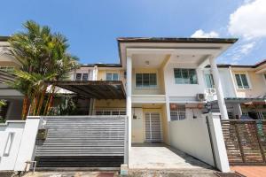 a white house with a gate in front of it at Landed 3BR Home Near Beach, Seafood & Fisherman Village in Bayan Lepas