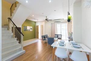 a dining room with a white table and chairs at Landed 3BR Home Near Beach, Seafood & Fisherman Village in Bayan Lepas