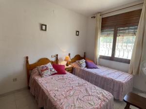 two beds in a room with a window at Holiday Home Zaragoza by Interhome in Miami Platja