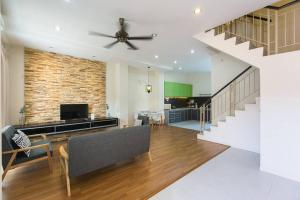 a living room with a couch and a ceiling fan at Landed 3BR Home Near Beach, Seafood & Fisherman Village in Bayan Lepas