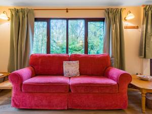 a red couch sitting in front of a window at Holiday Home Fishermans by Interhome in Inverness