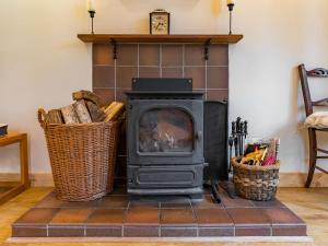 a wood stove in a living room with two baskets at Holiday Home Fishermans by Interhome in Inverness +23 photos