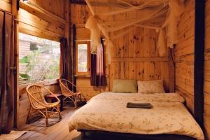 a bedroom with a bed in a wooden cabin at La Maison Homestay Măng Đen in Kon Tum