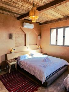 una camera da letto con un letto grande con soffitto in legno di Hotel Kasbah Riad Amnir a Mhamid