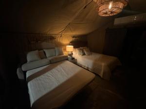 a bedroom with a bed and a lamp in a room at Jardin al Bosque-Glamping in San Juan