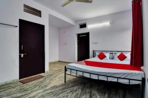 a bedroom with a bed with red pillows on it at Hotel O HM & Restaurant in Begās