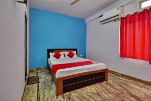 a bedroom with a bed with blue walls and red curtains at Hotel O HM & Restaurant in Begās