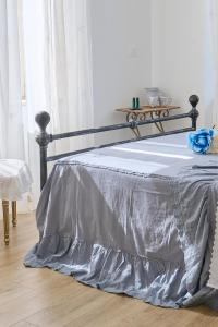 a bed with a gray bedspread on it in a room at B&B VillaPrimavera in Porto San Giorgio