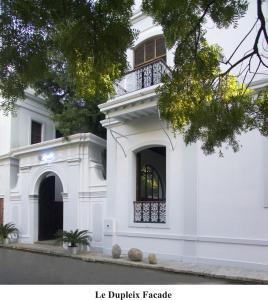 a white house with a balcony on the side of it at Le Dupleix in Puducherry