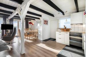 eine Küche mit weißen Schränken und ein Esszimmer in der Unterkunft Nice Home In Ebeltoft With 4 Bedrooms, Sauna And Wifi in Ebeltoft