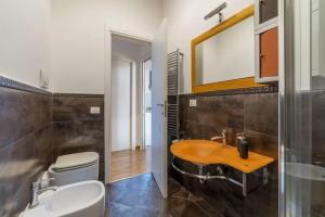 un bagno con lavandino, WC e specchio di Live Roma - Exclusive Penthouses a Roma Altre 33 foto