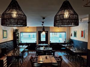 ein Restaurant mit Tischen, Stühlen und Kronleuchtern in der Unterkunft Merj's Guest House in Wolseley in Winnipeg