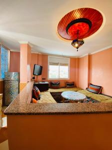 a large living room with orange walls and a large island at Taliouine Apartments in Taghazout +5 photos