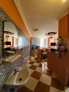 a bathroom with a sink and a checkered floor at Taliouine Apartments in Taghazout