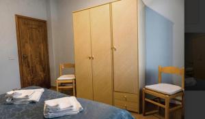 a bedroom with a bed and a cabinet and two chairs at Villa Paradiso Brenzone in Brenzone sul Garda +28 photos