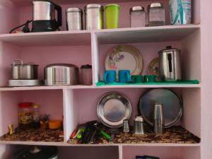 a shelf filled with pots and pans and dishes at Garden Villa, Hyderabad in Hyderabad