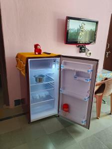 a refrigerator with its door open next to a table at Garden Villa, Hyderabad in Hyderabad