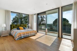 a bedroom with a bed and large glass windows at ViLLA LA SELVA PGA in Girona
