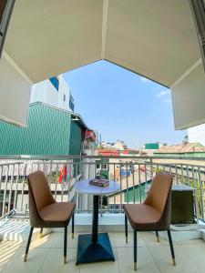 a balcony with two chairs and a table on a balcony at Eco Nest Apartment & Hotel Nam Ngư in Hanoi