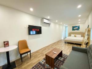 a living room with a bed and a tv on the wall at Eco Nest Apartment & Hotel Nam Ngư in Hanoi +6 photos