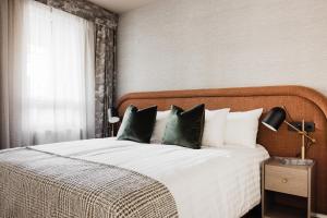 a bedroom with a large white bed with green pillows at Reykjavik Residence Apartment Hotel in Reykjavík