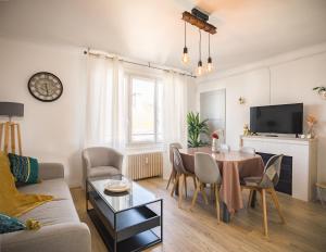 a living room with a table and a couch at Le May Flower - 3 Chambres - Proche Centre-Ville in Troyes